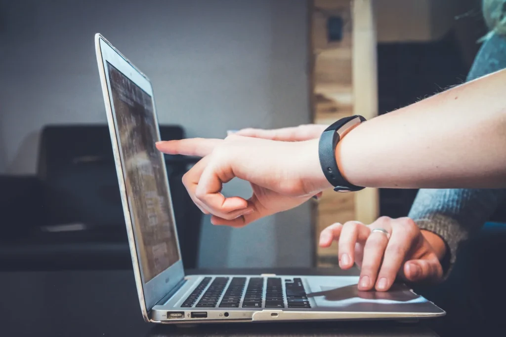 un professionista fa consulenza finestre indicando a un cliente informazioni sullo schermo di un portatile macbook