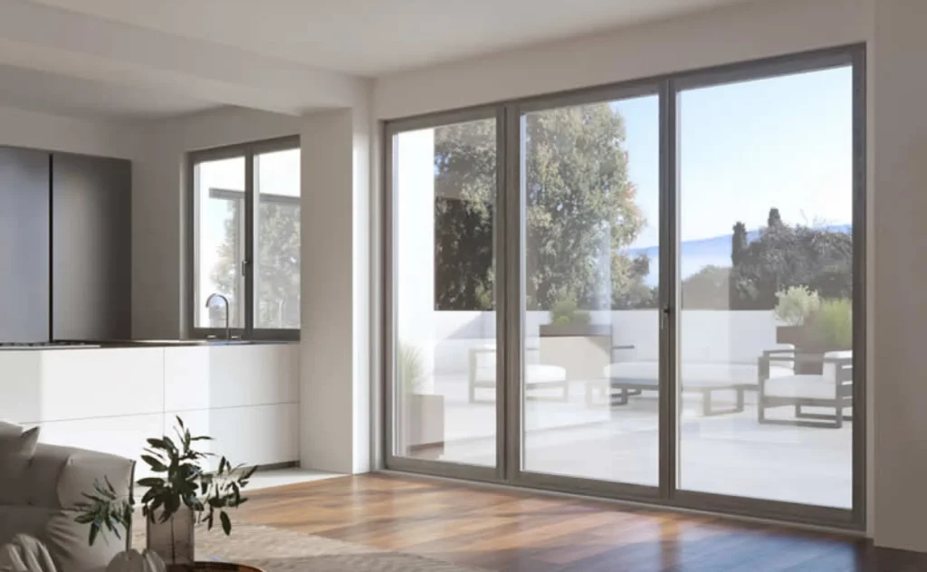Ampio soggiorno moderno con vetrate scorrevoli che offrono una vista panoramica sull'esterno, perfetto esempio di design suggerito da una consulenza finestre professionale.
