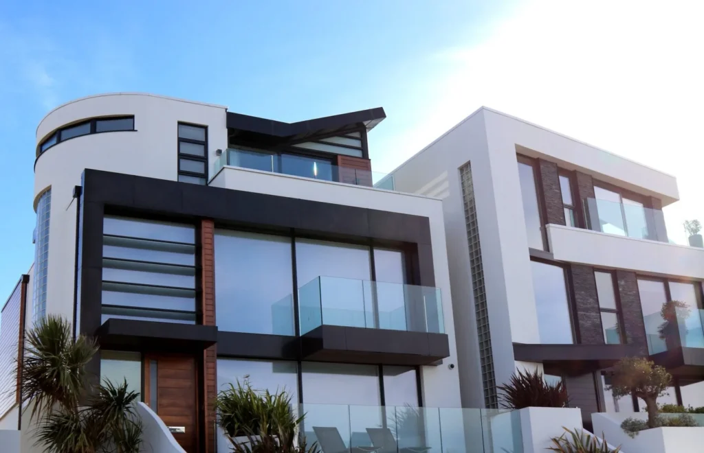 Facciata di una moderna villa con ampie finestre e balconi in vetro, dimostrando il risultato di una consulenza finestre mirata a massimizzare luce naturale e design contemporaneo.