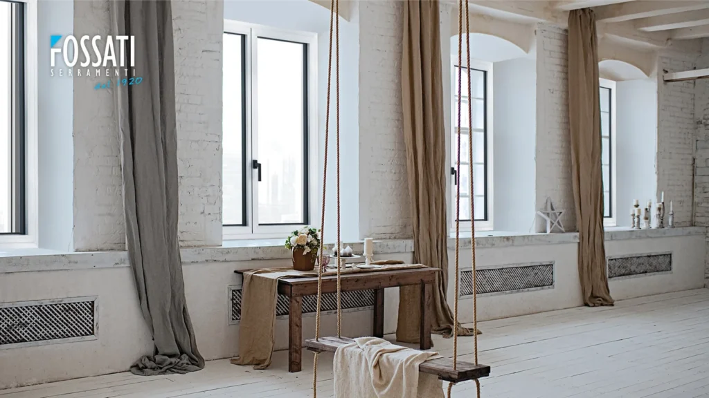 Ampio loft con finestre in alluminio infissi Aprilia, Fossati Serramenti, ambientazione luminosa con pareti in mattoni bianchi e arredamento dallo stile rustico moderno.