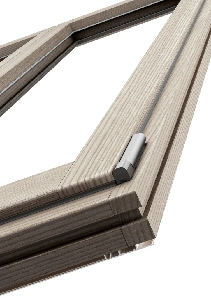 Primo piano di un angolo di finestra in legno chiaro con cerniera a scomparsa, esempio di infisso Gaeta con design moderno e finiture di pregio
