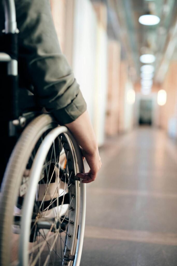 Persona in sedia a rotelle che si muove lungo un corridoio: l’accessibilità delle zanzariere è importante anche per chi ha mobilità ridotta.